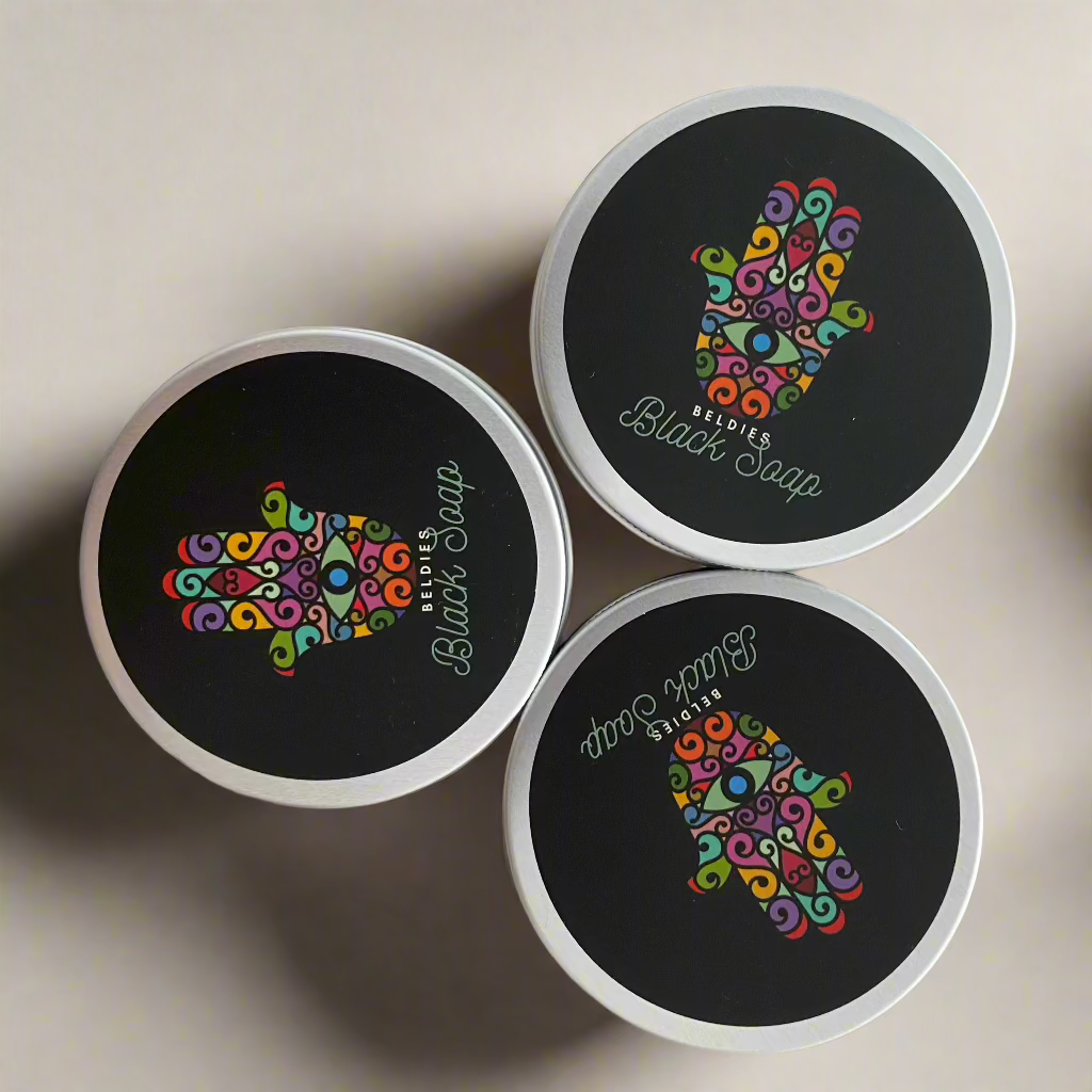 Jars of Beldies Moroccan Black Soap with a smooth, dark texture, ideal for exfoliation and cleansing as part of a traditional Moroccan hammam ritual.