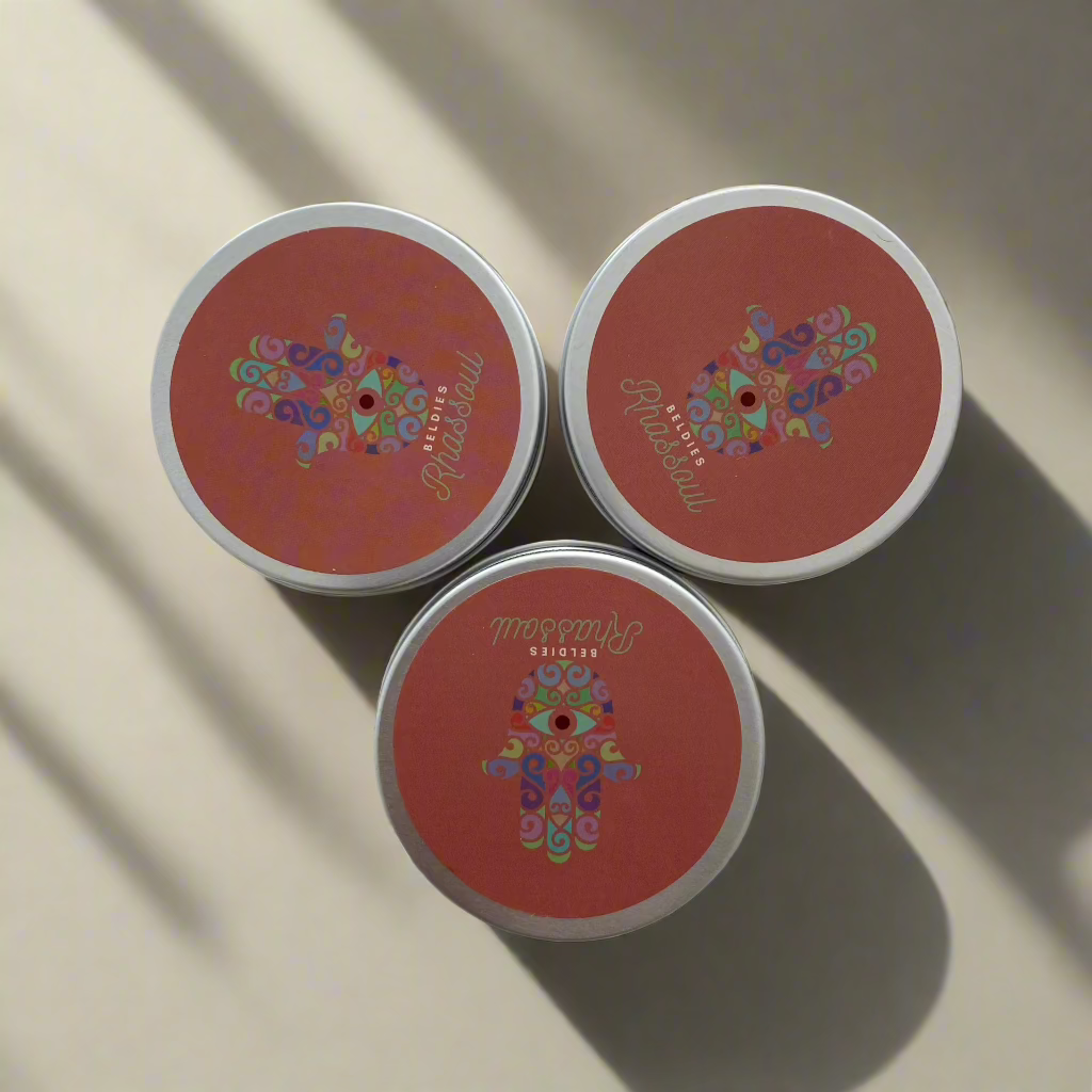 Beldies Rhassoul clay jars, sealed and ready for use, known for its detoxifying and rejuvenating properties for both face and body.