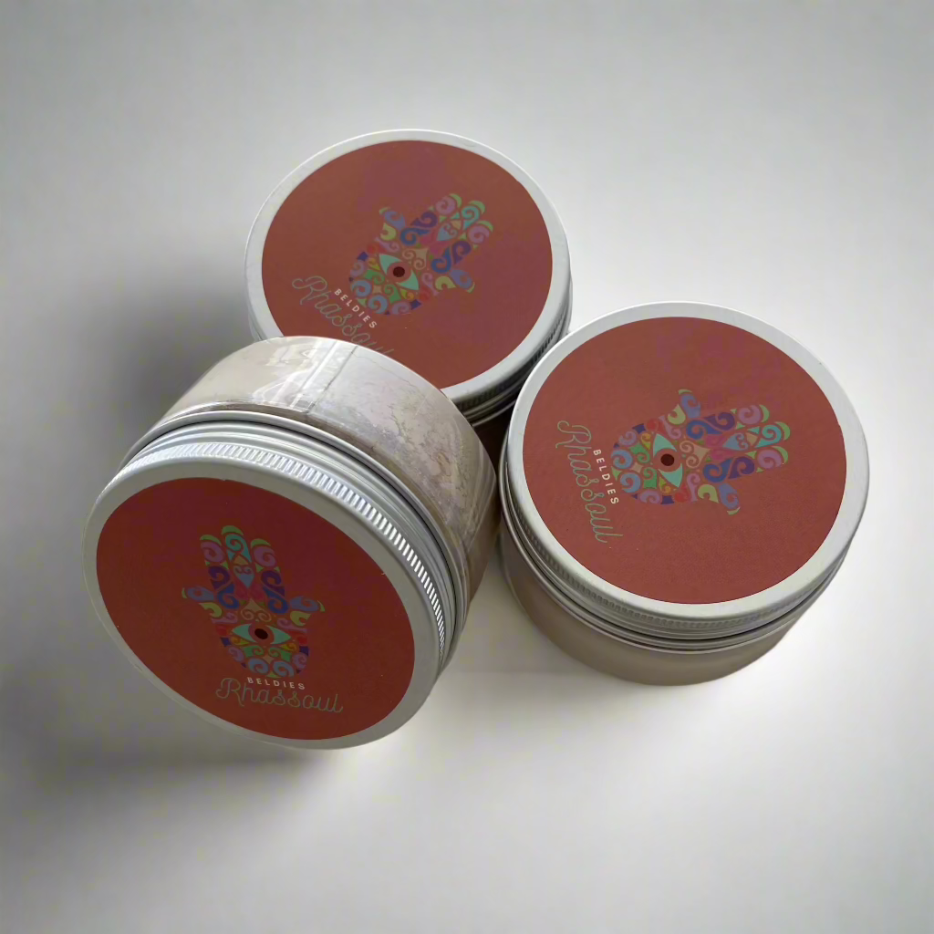Three closed jars of Beldies Rhassoul clay neatly arranged, each containing premium, all-natural clay known for its detoxifying and skin-nourishing properties, ideal for facial and body masks.