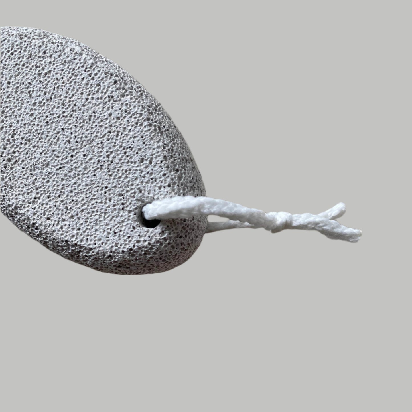 Close-up image of a Beldies pumice stone, showcasing its natural texture and ergonomic shape, designed for effective exfoliation and smooth skin care.