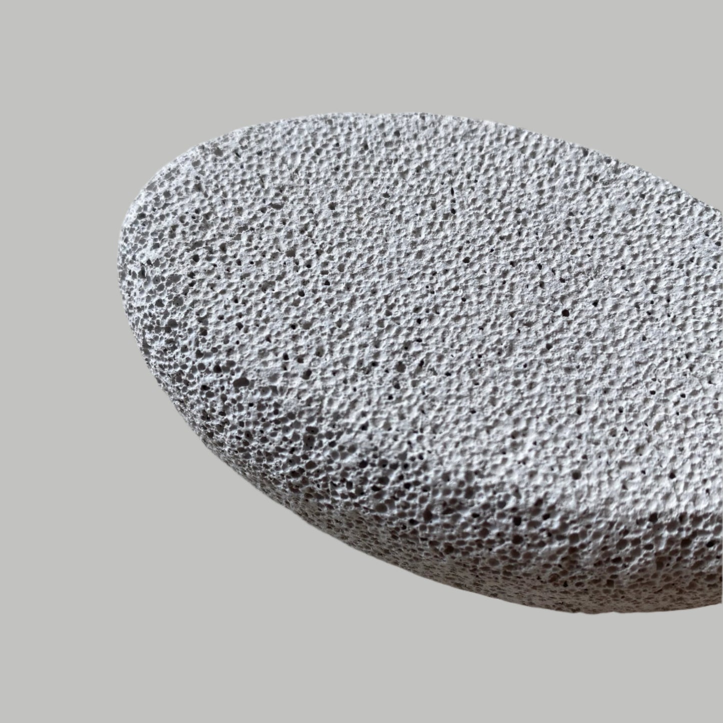 Close-up image of a Beldies pumice stone, showcasing its natural texture and ergonomic shape, designed for effective exfoliation and smooth skin care.