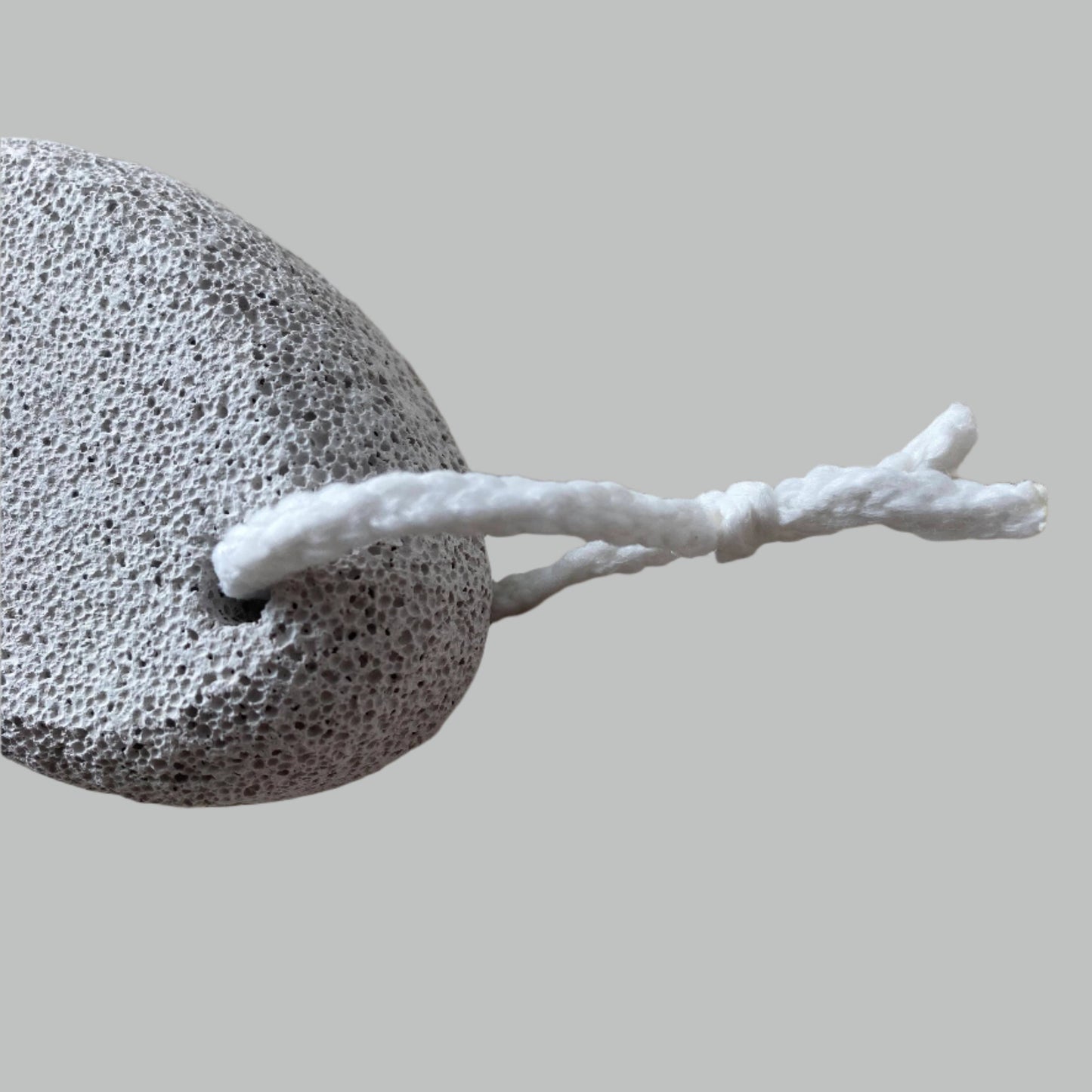 Close-up image of a Beldies pumice stone, showcasing its natural texture and ergonomic shape, designed for effective exfoliation and smooth skin care.