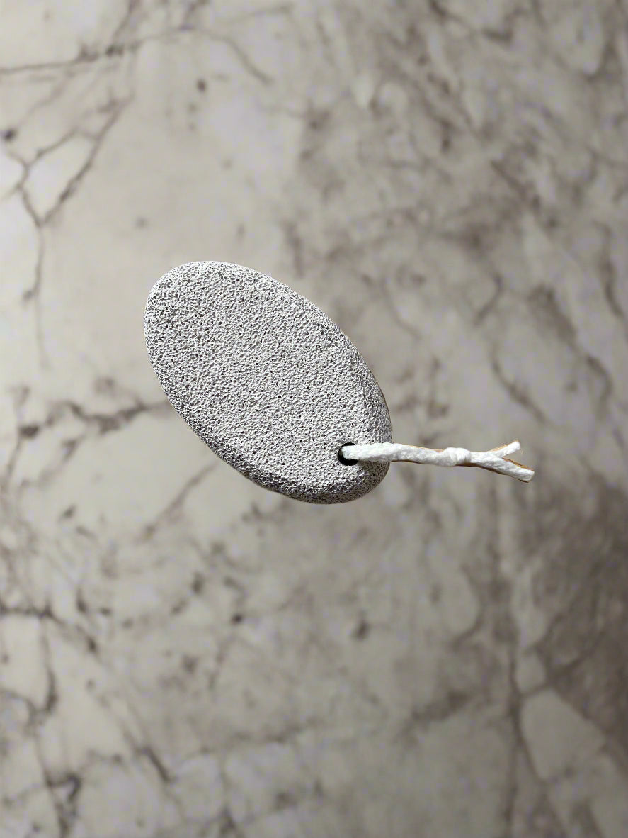 Close-up image of a Beldies pumice stone, showcasing its natural texture and ergonomic shape, designed for effective exfoliation and smooth skin care.