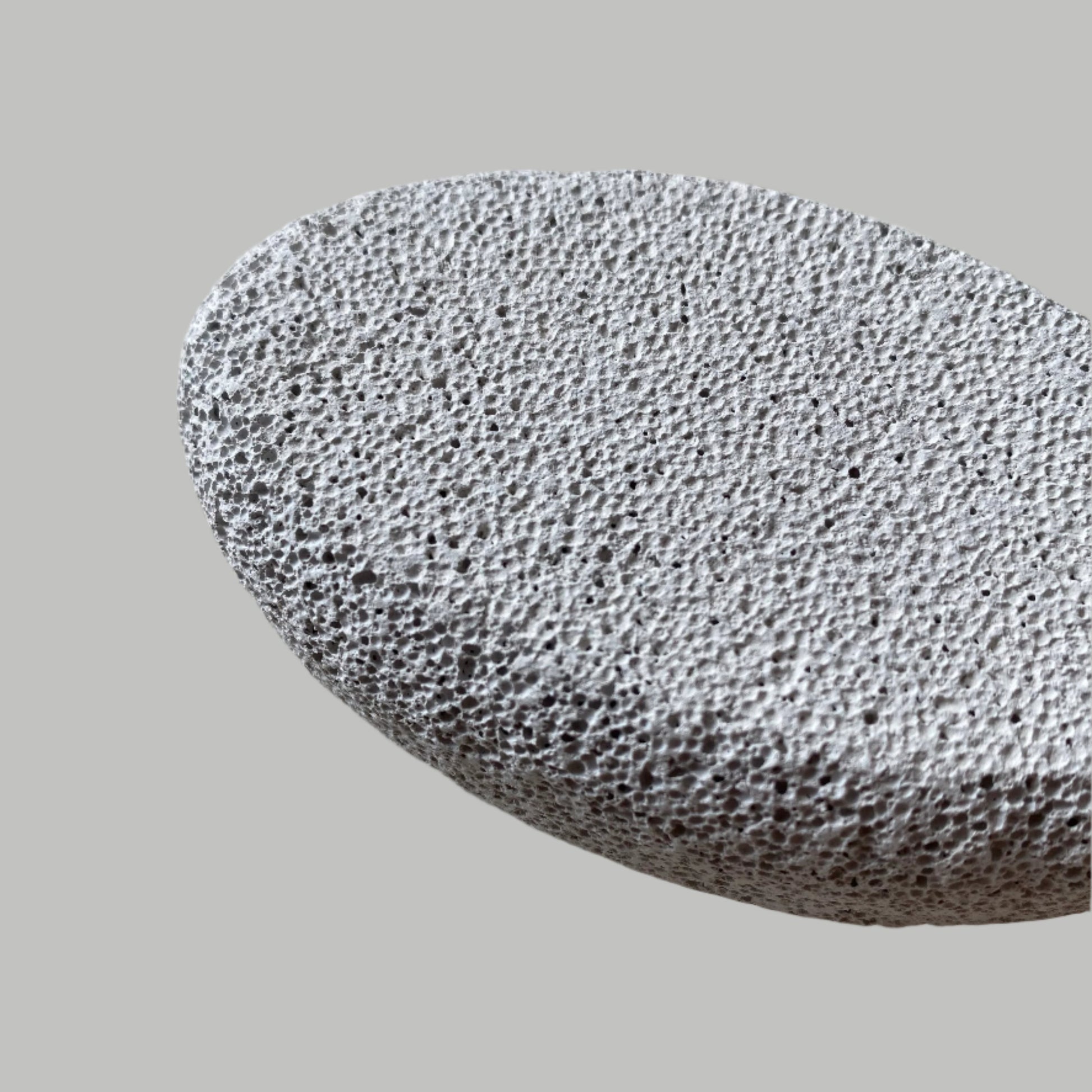 Close-up image of a Beldies pumice stone, showcasing its natural texture and ergonomic shape, designed for effective exfoliation and smooth skin care.