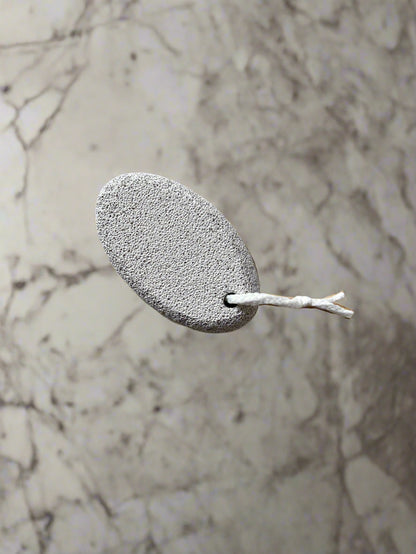 Close-up image of a Beldies pumice stone, showcasing its natural texture and ergonomic shape, designed for effective exfoliation and smooth skin care.